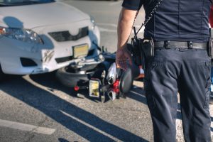 Police office at scene of an accident between a car and motorcycle.